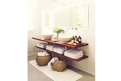 Sin puertas ni cajones, esta propuesta ofrece un espacio de guardado a la vista mediante el estante inferior. Los canastos, por su parte, no sólo aportan estética sino además un lugar extra para guardar toallas