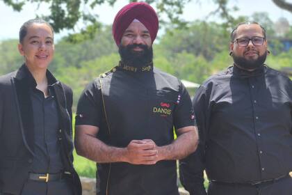 Singh junto a empleados de su cadena de barberías