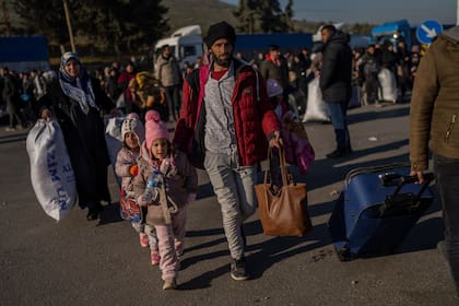 Sirios ingresan a su país desde el punto de cruce turco de Cilvegozu, en Reyhanli, sureste de Turquía, el sábado 18 de febrero de 2023, casi dos semanas después del último sismo. (Foto AP/Bernat Armangue)