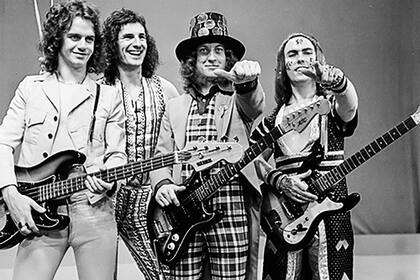 Slade, la banda que compuso el tema en los 70 y que tuvo un gran éxito en toda Gran Bretaña; al mercado norteamericano recién pudieron entrar en los 80, de la mano de la versión de Quiet Riot