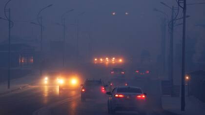 Los autos manejan a través de la gruesa niebla del smog en una fria y contaminada mañana en Ulaanbaatar