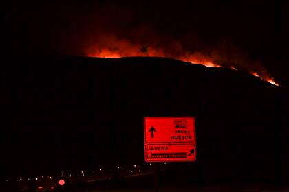 Smoke and fire billows from the top of a hill as forest fire affects the zone near Liedena around 40 kilometers (24 miles) from Pamplona, northern Spain, Thursday, June 16, 2022. Spain's weather service says a mass of hot air from north Africa is triggering the country's first major heat wave of the year with temperatures expected to rise to 43 degrees Celsius (109.4 degrees Fahrenheit) in certain areas. (AP Photo/Alvaro Barrientos)