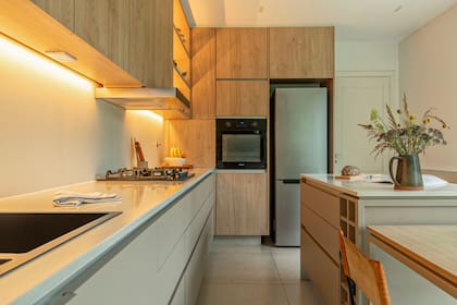 Sobre el horno empotrado, el microondas se oculta tras una puerta.