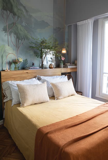 Sobre el respaldo de madera, detalles botánicos, luces pequeñas y flores. Cover, almohadones de red y pie de cama (Flora E.).