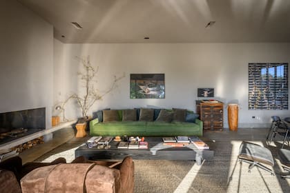 Sobre el sofá tapizado en pana verde (Interiores B.AP), obra del argentino Hugo Aveta. A continuación, una antigua planera de madera y una fotografía del chileno Pablo Zuleta Zahr