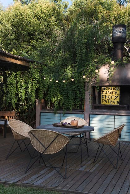 Sobre estas líneas, la parrilla sobre deck de madera, en el extremo del quincho más cercano a la casa.