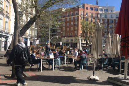 Sobre la calle Fuencarral, la gente disfrutaba del buen tiempo al aire libre tomando café y cañas en las terrazas