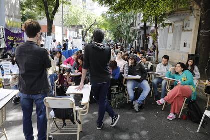 Sobre la calle Santiago del Estero, cortada al tránsito con cintas de peligro y pupitres, se dictan al menos 15 clases a la vez a los alumnos de la Facultad de Ciencias Sociales