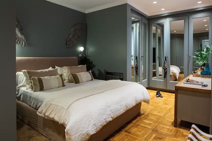 Sobre la cama de dos plazas del dormitorio principal cuelgan unas alas de metal, hechas por un artesano.