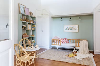 Sobre la cama heredada, cuadro (Jufish). Alfombra y almohadones (Another Home). Manta de lana (Luna Deco). Juguetes de madera (Lola y Chango). Mesa, sillas (Casa Perri). Biblioteca (Mercado Libre).
