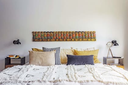 Sobre la cama del dormitorio principal, manta con lentejuelas, almohadones de terciopelo alargado, color natural con flecos, de red y de terciopelo y lino (todo de Sol Palou Deco).