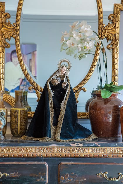 Sobre la cómoda, el gran protagonismo lo tiene esta imagen de Nuestra Señora de Dolores. Es una virgen italiana, del siglo XVII, con pies de madera, que Adrián, que es muy creyente, compró en un anticuario de José Ignacio, Uruguay. 