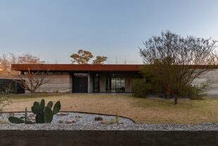 Sobre la losa se apoya una “tapa” de chapa aluminizada, que se ve como una cenefa oxidada que recorre el perímetro. El paisajismo fue diseñado con especies nativas: con mejor adaptabilidad, representan a la región y favorece la fusión con el entorno.