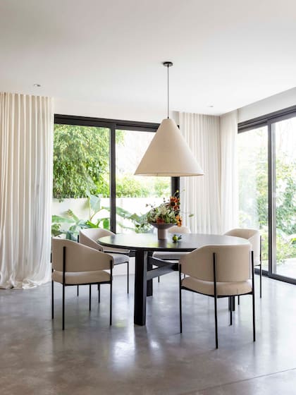 Sobre la mesa ‘Cruce’ con sillas ‘Torek’ (todo de Urbano Estudio), lámpara colgante cónica (Iluminación Agüero)