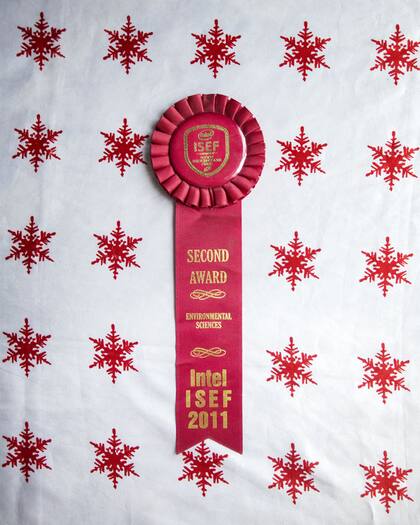 Sobre la mesa, el premio que recibió en 2011 con un grupo de estudiantes.