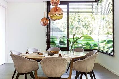 Sobre la mesa, lámpara ‘Melt’ color cobre del célebre diseñador inglés Tom Dixon.