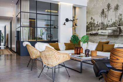 En el ambiente principal se conservaron los pisos de cemento alisado. Sobre la mesa ratona, comprada en un mercado belga, antiguas botellas de farmacia. Sofá hecho a medida por Paula Guillani.