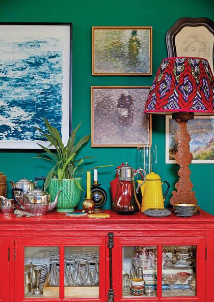 Sobre la pared verde, se destaca la pantalla hecha en un textil nigeriano también conocido como Ankara.