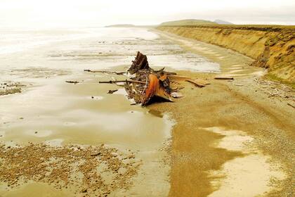 Sobre la playa se ven los restos oxidados del Desdémona, un buque naufragado en 1985