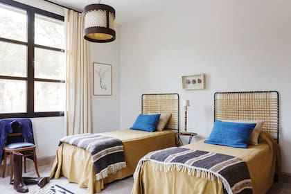 Sobre las camas con respaldo de tiento, almohadones de barracán azul (todo de Malena Ana).