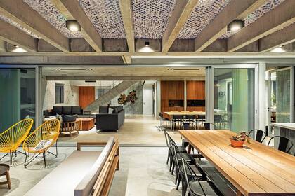 Sobre las vigas del techo, una red de sombreo (Ormiflex). Mesa de incienso (Las Marinas) y sillas ‘Tolix’ (De Sillas). A la derecha de la mesa hay una parrilla en hierro y una mesada de Igneastone (Marmolería Itatí) con bacha (Johnson).