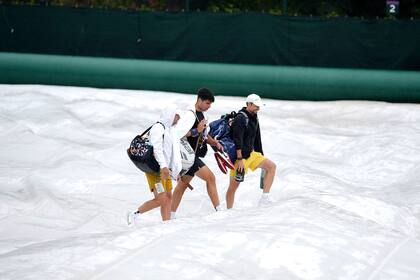 ¿Sobre nieve? No. Carlos Alcaraz y su cuerpo técnico caminan sobre los cobertores de cancha del All England