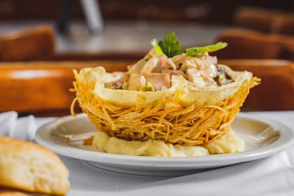 El pollo en una canasta de papas fritas es el plato emblemático del restaurante.