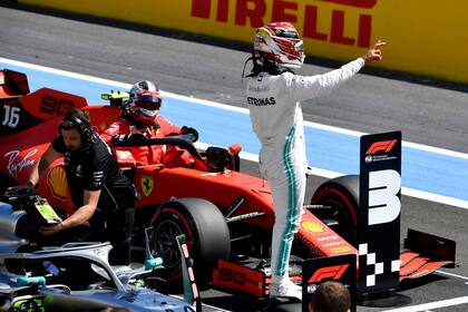 Sobre su Mercedes, Lewis Hamilton celebra en Paul Ricard la 86ª pole position de su trayectoria; Charles Leclerc sale de su Ferrari tras alcanzar la tercera posición de largada.