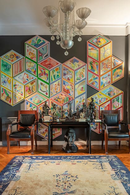 Sobre una de las paredes del living, una inmensa obra de Pablo Rosales acompaña a la colección de bronces de artistas argentinos de 1920 hasta hoy. Araña de Murano y alfombra china antigua.