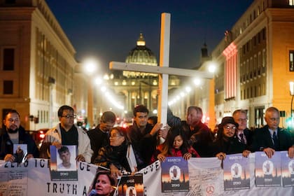 Sobrevivientes de abusos sexuales sostienen una cruz mientras se congregan frente a la Plaza de San Pedro del Vaticano, durante una vigilia por las víctimas de abusos sexuales, en Roma, el 21 de febrero de 2019