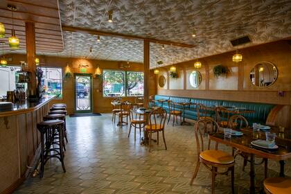 Sobrio y chic, el bistró incluye mucha madera, tonos verdes, luces cálidas y sillas Thonet.