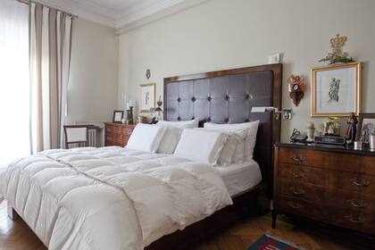 Sobrio y formal, esta opción en cuero con capitoné y marco de madera lustrada sabe conjugarse con las cómodas antiguas a los costados de la cama