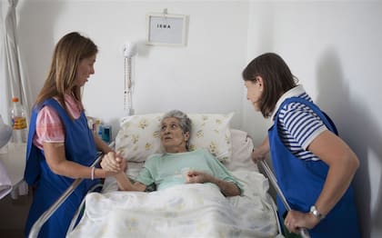 Socorro Ham y Pilar Vallilengua, voluntarias del hospice San Camilo, junto a Irma, una de las huéspedes