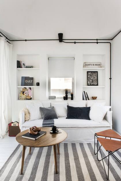 Sofá (Casa The Stock). Mesa baja, almohadones, banquitos (todo de Good Luck Casa). Alfombra (Elementos Argentinos).