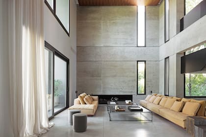 Sofá hecho a medida (Estudio Karina Kreth) y mesas bajas en hierro y madera (Federico Churba).