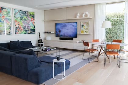 Sofá ‘Lazy’, mesa baja ‘Elías’, mesa redonda ‘Júpiter’, mueble para la tele (todo de Estudio XFB). Sillas ‘Q’ (Números Primos). Lámpara ‘Tolomeo’ de Artemide. Cuadros de Luciana Garabello.