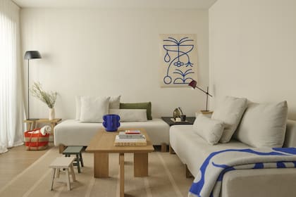 Sofás ‘Cala’ sin apoyabrazos, con respaldo parcial y almohadones largos, mesa ‘Río’ (todo de Loom Haus). Vaso de cerámica azul (Castro Corbat). Alfombra (Mercer).