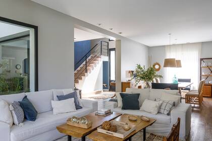 Sofás (Living Design BA). Mesas de centro con tapa de zoita y patas de hierro, sillas materas, almohadones, alfombra y cortinas de gasa (Ritta Estudio).