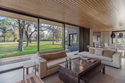 Sofás tapizados en lino y mesas ratonas en cuero crocco y cerezo macizo (todo de Pía Fradusco Interiores). Alfombra de Marruecos. Lámparas colgantes tejidas a mano con hilo de yute.