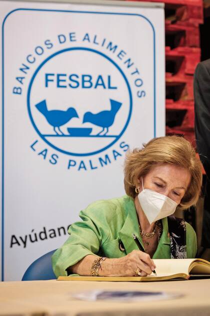 Firmando durante su visita al Banco de Alimentos de las Palmas de Gran Canaria, dentro del marco de la gira que está llevando a cabo por España, en apoyo a las autoridades en su labor durante la pandemia