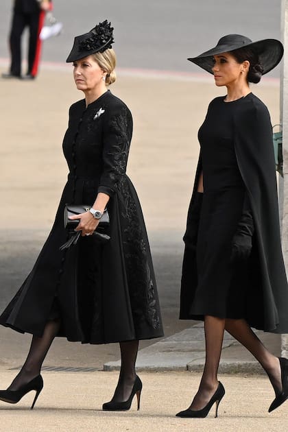 Sofía, la condesa de Wessex (con vestido de Suzannah London), junto a Meghan, duquesa de Sussex, con un diseño de mangas capa de Stella McCartney y guantes largos. Llevó pendientes de perlas y diamantes que la Reina le regaló durante su compromiso oficial en junio de 2018.