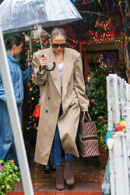 A Jennifer Lopez la lluvia la agarró de shopping. La actriz fue a comprar un bolso de Louis Vuitton después de almorzar en el restaurante Ivy en Los Ángeles. Elegante como siempre, JLO lució unos lentes de sol, un abrigo largo marrón y un bolso Dior