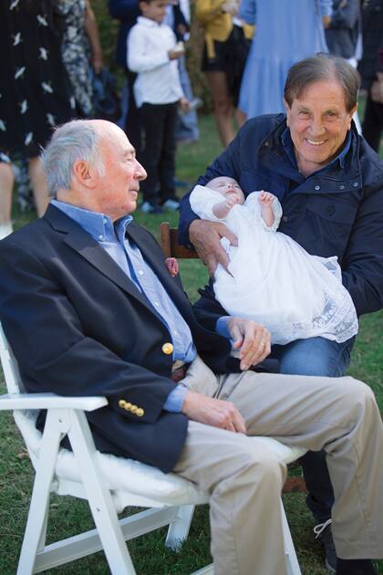 Los abuelos Marcos Uranga y Quique Estevanez posan con su nieta.