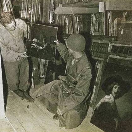 Soldados aliados exhiben la pintura El astrónomo, de Johannes Vermeer, recuperada tras la Segunda Guerra Mundial