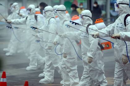 Soldados con trajes especiales desinfectan un tren en Corea del Sur