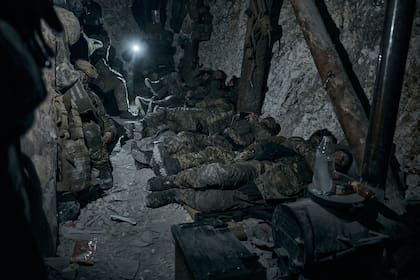 Soldados de la 3ra brigada de asalto de las fuerzas especiales del ejército ucraniano (SSO), "Azov", descansan en una zona resguardada tras una noche de combates cerca de Bakhmut, en la región de Donetsk, Ucrania, el 11 de febrero de 2023. (AP Foto/Libkos)