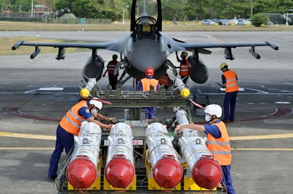 Soldados de la Fuerza Aérea taiwanesa se preparan para cargar misiles antibuque Harpoon AGM-84 de fabricación estadounidense frente a un avión de combate F-16V durante un simulacro en la base de la Fuerza Aérea de Hualien el 17 de agosto de 2022. 
