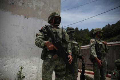 Soldados del ejército mexicano vigilan el perímetro durante la reunión entre las autoridades locales y los miembros de la agrupación "El Machete"