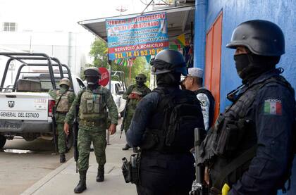 Soldados del Ejército Mexicano y miembros de la Policía Estatal revisan la zona donde fue asesinado el periodista mexicano Nelson Mateus en la ciudad turística de Acapulco, estado de Guerrero, México, 15 de julio de 2023. (Foto de FRANCISCO ROBLES / AFP)
