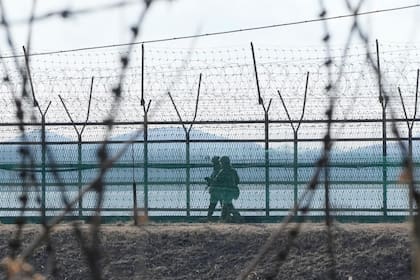 Soldados del ejército surcoreano patrullan junto a la cerca de alambre de espino en Paju, Corea del Sur, cerca de la frontera con Corea del Norte, el jueves 16 de febrero de 2023. (AP Foto/Ahn Young-joon)